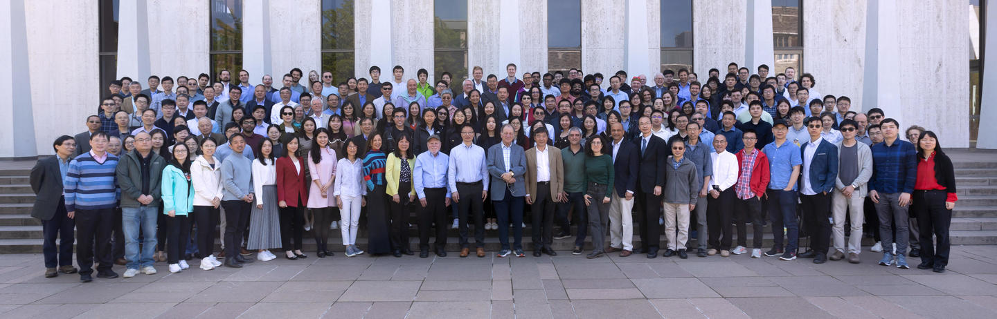 A group of conference attendees gathered outside Robertson Hall